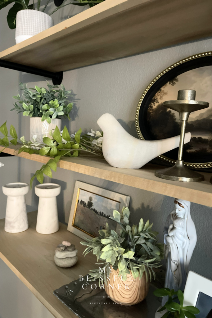 Open shelf styling with framed art, stacked books, candles, and meaningful decorative pieces.