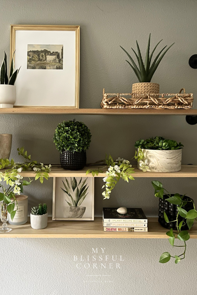 Wood floating shelves styled with plants, framed artwork, books, and neutral decorative accents.