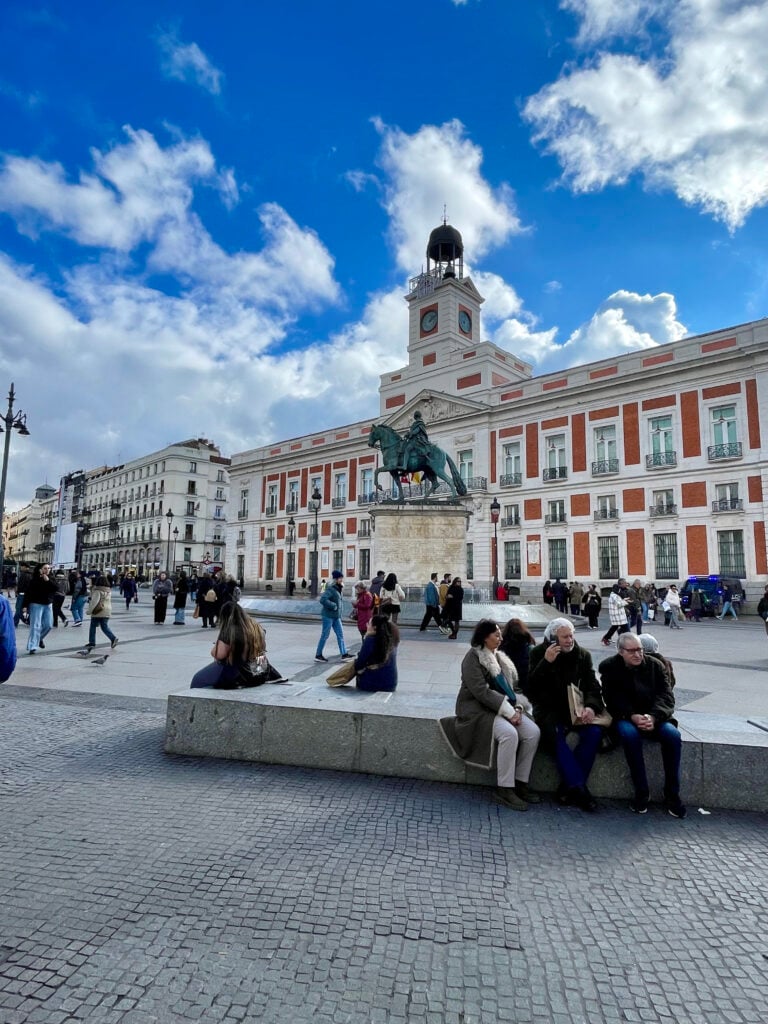 Plaza Mayor in Madrid with people relaxing in the open square on a sunny day