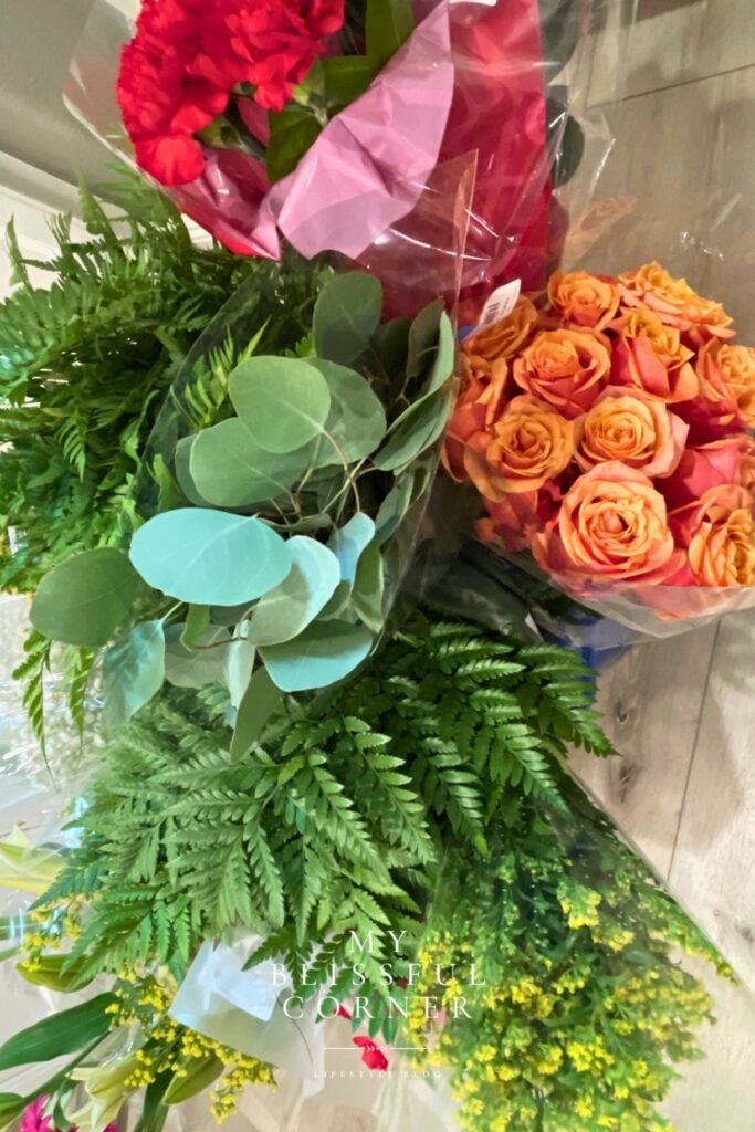 Trader Joe’s flowers used for tropical floral arrangements with roses eucalyptus and greenery