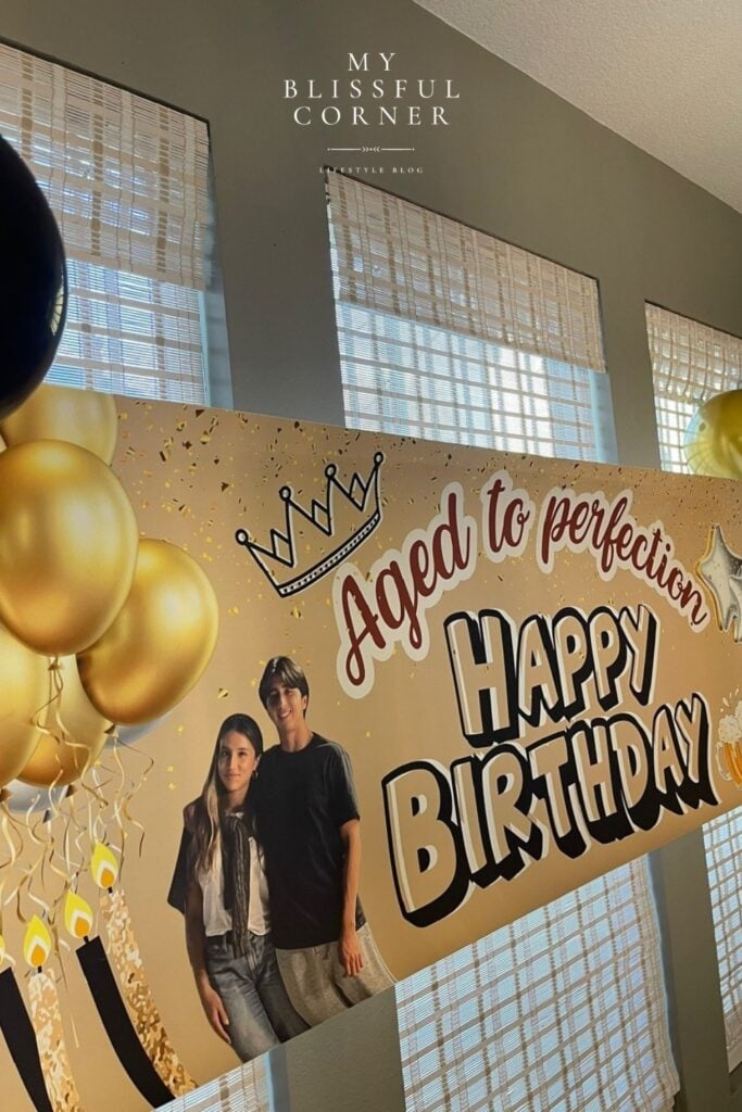 Custom happy birthday banner for him with aged to perfection text and gold balloon design used as a party photo backdrop