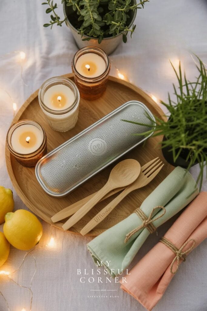 Summer backyard party essentials flat lay with candles, cloth napkins, wooden utensils and string lights