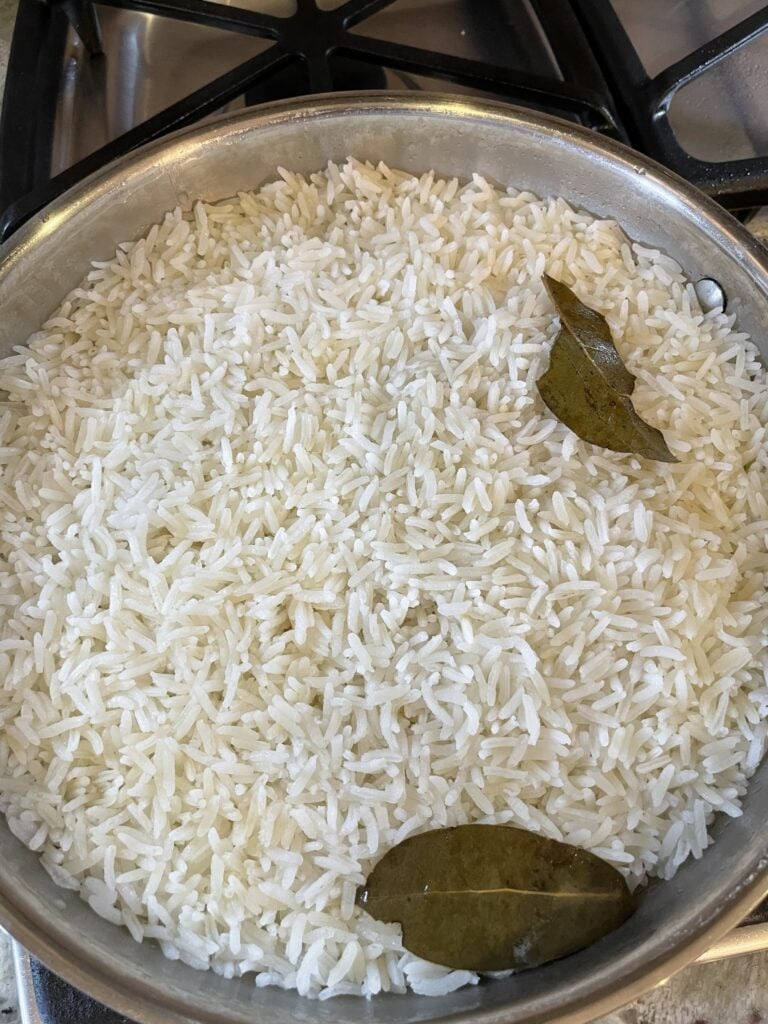 cooked cilantro lime rice with bay leaves in a pot